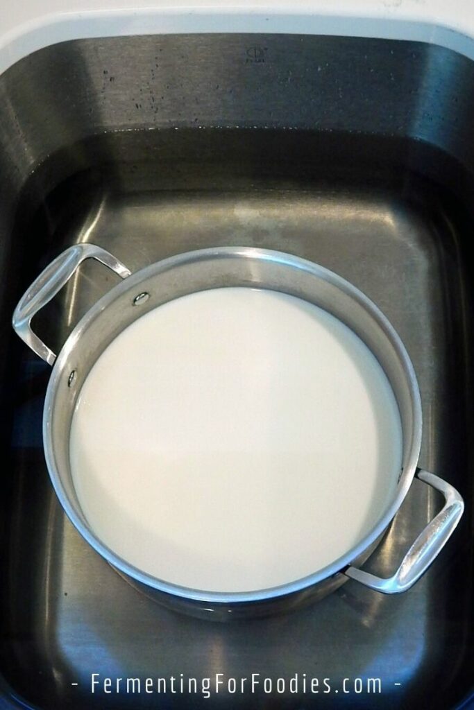Milk in a sink of hot water to maintain the temperature.