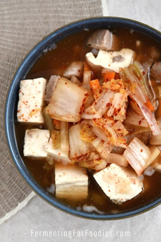 A bowlful of pork belly kimchi soup with tofu.